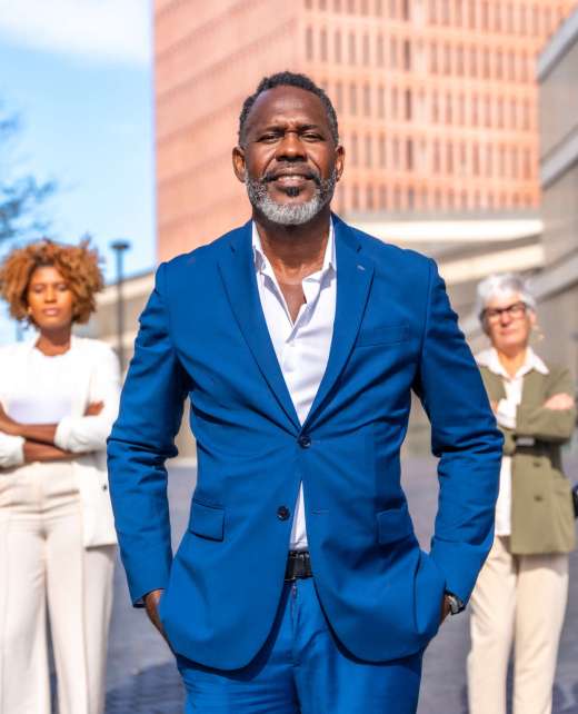Portrait of a mature african american businessman and work team standing outdoors in a sunny day next to a financial building